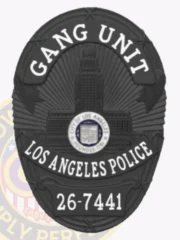 Black custom oval metal badge for Los Angeles police gang unit highlighting a textured city hall emblem in the center of a dark shield, with bold white text GANG UNIT at the top and LOS ANGELES POLICE in the middle, along with a black number plate 26-7441 at the base, designed with safety pin fastening.