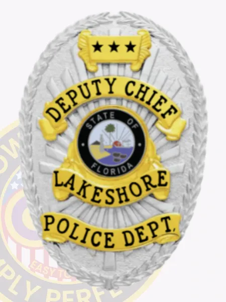 Silver oval custom metal badge for Lakeshore police deputy chief, highlighted by embossed laurel leaves around the edge, radiant sunburst design, gold banners featuring black text "DEPUTY CHIEF," "LAKESHORE," and "POLICE DEPT.," with a three-star gold plate above and the State of Florida seal centered.
