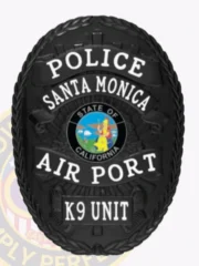 A custom metal badge in black, prominently displaying the word "POLICE" at the top, followed by "SANTA MONICA" above the central emblem. The badge features the "STATE OF CALIFORNIA" emblem at its center, with "AIR PORT" below it and "K9 UNIT" at the bottom. The all-black design gives it a sleek and authoritative appearance, showcasing its detailed craftsmanship.
