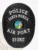 A custom metal badge in black, prominently displaying the word "POLICE" at the top, followed by "SANTA MONICA" above the central emblem. The badge features the "STATE OF CALIFORNIA" emblem at its center, with "AIR PORT" below it and "K9 UNIT" at the bottom. The all-black design gives it a sleek and authoritative appearance, showcasing its detailed craftsmanship.