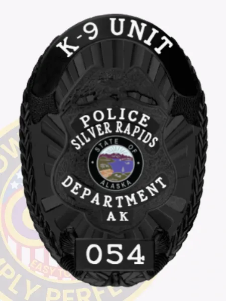 This striking black custom metal badge showcases "K-9 UNIT" in bold letters at the top, with "POLICE SILVER RAPIDS" prominently displayed in the center. The badge features a circular emblem indicating "STATE OF ALASKA," along with "DEPARTMENT AK" and "054" at the bottom. The safety pin attachment allows for easy and reliable fastening on official attire.