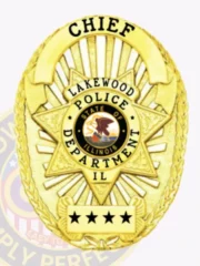This custom metal badge in gold features a striking star design, prominently displaying "CHIEF" at the top. The center showcases a circular emblem with "LAKEWOOD POLICE DEPARTMENT," the state seal of Illinois, and "IL," while three stars are highlighted below, all securely attached with a safety pin for easy wear.