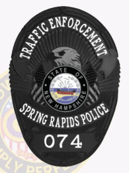 This elegant custom metal badge in black features "TRAFFIC ENFORCEMENT" at the top in bold letters. The central design showcases an eagle emblem, framed by a circular insignia stating "STATE OF NEW HAMPSHIRE," and the text "SPRING RAPIDS POLICE" along with "074." The badge is designed with a velcro attachment for convenient wear.