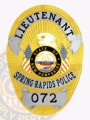 This custom metal badge in gold showcases stylish silver panels, highlighting "LIEUTENANT" boldly at the top. The centerpiece features an eagle, framed by a circular emblem that reads "STATE OF NEW HAMPSHIRE," along with the text "SPRING RAPIDS POLICE" and the number "072." The badge comes with a velcro attachment for convenient fastening.