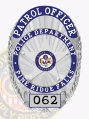 This striking custom metal badge in silver highlights "PATROL OFFICER" across the top, followed by "POLICE DEPARTMENT PINE RIDGE FALLS" in the center. The central design features a star emblem representing "STATE OF ARKANSAS," while "062" is displayed at the base. Designed with a safety attachment, this badge allows for easy and reliable wear.