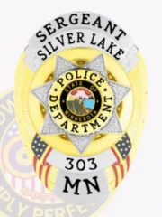 Gold oval custom metal badge for Silver Lake police sergeant, highlighted by a central silver 7-point star featuring the State of Minnesota emblem, black text on silver ribbons reading "SERGEANT," "SILVER LAKE," "POLICE DEPARTMENT," and "303 MN," with American flags on each side.