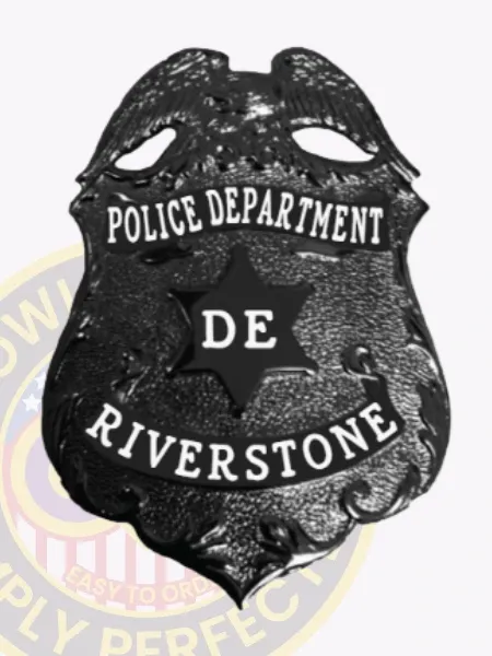 Black eagle top shield metal badge for Riverstone Police, displaying a detailed black eagle at the top, white lettering stating "POLICE DEPARTMENT," a black six-point star with white "DE" in the center, and "RIVERSTONE" on the bottom banner, designed with safety pin attachment.