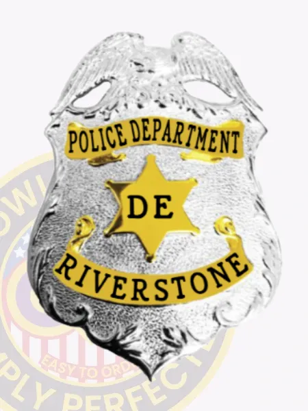 Police Department badge for Riverstone in silver metal featuring a prominent silver eagle at the top, gold banners with black text for "POLICE DEPARTMENT" and "RIVERSTONE," a central gold six-point star marked with "DE," secured with safety pin.