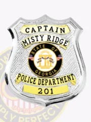 Custom silver shield metal badge with gold panels for Misty Ridge police the captain with safety pin attachment, showing a polished silver shield with gold text bands labeled "CAPTAIN," "MISTY RIDGE," "POLICE DEPARTMENT," and a bottom banner with "201," plus a circular Georgia seal in the middle.