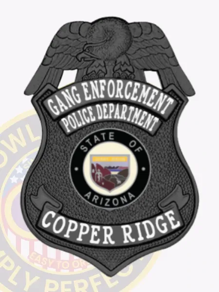 Black metal shield badge for Copper Ridge police gang enforcement, topped with a black eagle, displaying white lettering for "GANG ENFORCEMENT" and "POLICE DEPARTMENT" on upper silver panels, the Arizona state seal in black and white at the center, and "COPPER RIDGE" on the bottom banner, secured with a safety pin.