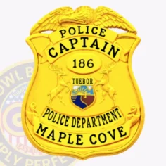Bright gold eagle top shield police badge for maple cove captain, displaying bold black letters "police captain," a gold oval center marked "186," a multicolor state seal emblem, and bottom banners with "police department" and "maple cove," featuring a safety pin attachment on the back.