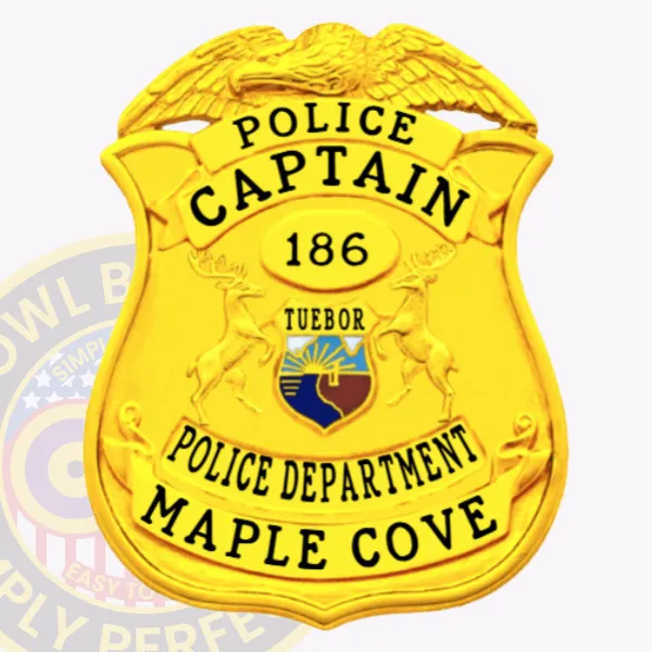 Bright gold eagle top shield police badge for Maple Cove captain, displaying bold black letters "POLICE CAPTAIN," a gold oval center marked "186," a multicolor state seal emblem, and bottom banners with "POLICE DEPARTMENT" and "MAPLE COVE," featuring a safety pin attachment on the back.