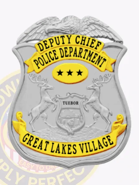 Silver eagle top shield metal badge with bright gold text panels for Great Lakes Village police deputy chief, bearing black letters on gold banners reading "DEPUTY CHIEF" and "POLICE DEPARTMENT," centered by a gold oval with three black stars, featuring a safety pin on the back.