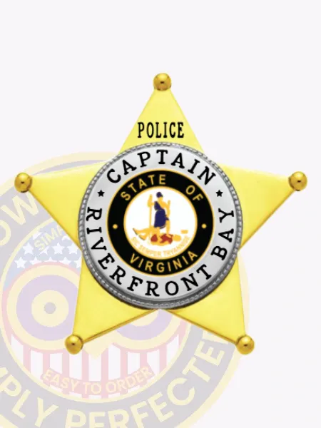 Gold metal 5 point star badge with silver panels for Riverfront Bay Police Captain, including black lettering “POLICE CAPTAIN RIVERFRONT BAY” framing the Virginia state seal in the center, equipped with a safety pin.