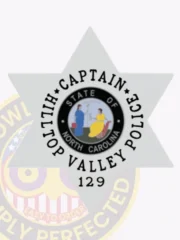 A striking silver custom 6 pointed star metal badge for Hilltop Valley Police showcases "CAPTAIN" prominently around the center, which features the North Carolina state seal. Designed with a safety pin attachment, it combines elegance and functionality for officers on duty.
