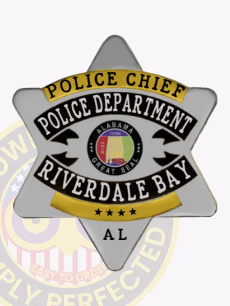 Six-point star silver metal badge for Riverdale Bay Police Chief, featuring a gold banner at the top inscribed with "Police Chief," black bands with white text for "Police Department" and "Riverdale Bay" framing the colorful Alabama Great Seal in the center, a gold section with four stars near the base, and the state abbreviation "AL," attached via safety pin.