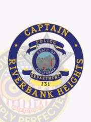 A distinctive custom badge displays a prominent silver star surrounded by a blue circle banner. The title "CAPTAIN" is featured prominently above, while "RIVERBANK HEIGHTS POLICE DEPARTMENT" encircles the star. The badge highlights blue reverse enamel panels and gold accents, designed with a safety pin attachment for practical use.