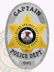 This custom metal badge in silver features elegant gold accents, prominently displaying "CAPTAIN" at the top. The center showcases a star emblem with "RIVER SPRINGS CITY POLICE DEPARTMENT," the state seal of Illinois, and "IL," while the number "081" is highlighted below, all securely attached with a safety pin for easy wear.