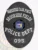 This custom metal badge in black prominently features "NARCOTICS TASK FORCE" at the top in bold white letters, creating a sharp contrast against the dark background. The center displays a circular emblem with "STATE OF NEW YORK," surrounded by decorative elements. Below, "BROOKSIDE FIELDS," "POLICE DEPT.," and the number "095" are clearly inscribed. A safety pin attachment ensures secure wear on uniforms.
