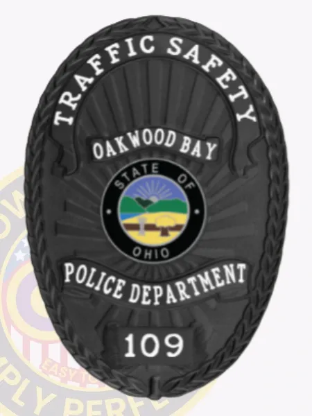 Distinctive black custom metal badge featuring "TRAFFIC SAFETY" inscribed prominently at the top in clean white text. The badge showcases a detailed design, with "OAKWOOD BAY" and "STATE OF OHIO" surrounding a circular emblem, and includes "POLICE DEPARTMENT" with the number "109," all complemented by a reliable safety pin attachment for practicality.