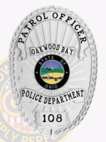 Bright silver custom metal badge displaying "PATROL OFFICER" at the top in bold lettering. The oval design features "OAKWOOD BAY," the state name, and a central emblem, along with "POLICE DEPARTMENT" and "108," secured by a functional safety pin attachment for easy fastening.