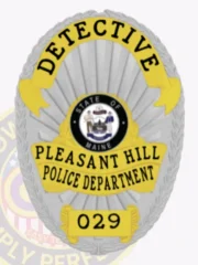 An elegant custom metal badge in silver showcases a traditional oval design with striking gold accents. The words "DETECTIVE" are prominently featured at the top in bold black font. The center highlights the Maine state emblem, framed by "PLEASANT HILL POLICE DEPARTMENT." The lower part includes "029," all in clear black text. A safety pin attachment allows for convenient wear.