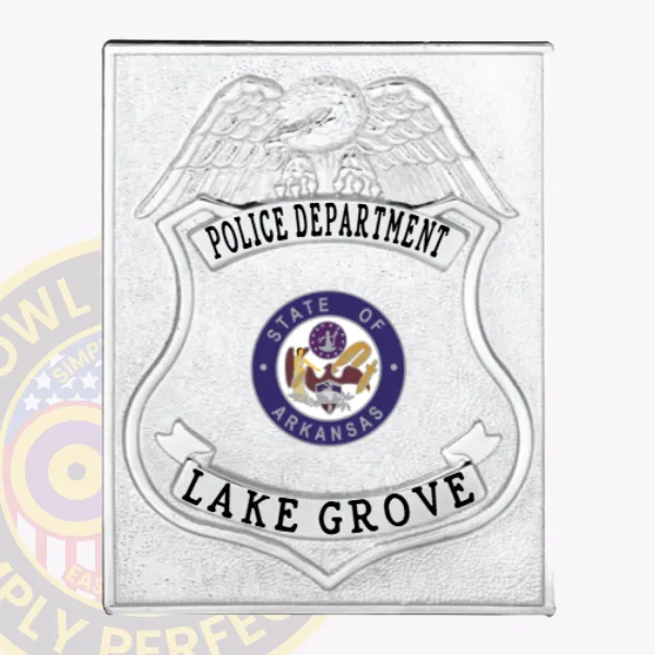 Square silver metal badge for Lake Grove police department with a silver eagle perched on top, black font on banners displaying "POLICE DEPARTMENT" and "LAKE GROVE," encircling the blue and gold circular Arkansas state seal at the center, secured by a safety pin attachment.