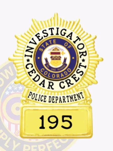 Circle starburst gold metal badge on square base for Cedar Crest police investigator, featuring a gold sunburst design, black text reading "Investigator" and "Cedar Crest" around the Colorado state seal in the center, a gold banner with "Police Department," and a base labeled "195," attached with safety pin.