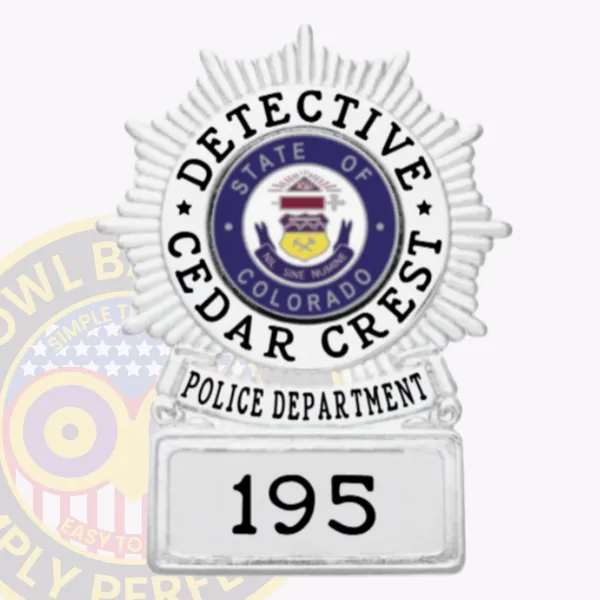 Silver circle starburst metal badge on square base for Cedar Crest police detective, showing a textured silver starburst encircling the detailed State of Colorado seal, black lettering reading "Detective" and "Cedar Crest," a silver banner with "Police Department," and a base numbered "195," including safety pin attachment.