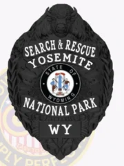 A custom badge with a bison head in black color, featuring the words 'SEARCH & RESCUE YOSEMITE' prominently displayed at the top. The badge includes the state emblem of Wyoming in the center, surrounded by decorative elements. The overall design is sleek and authoritative, emphasizing its importance for search and rescue operations.