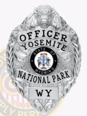 A custom badge with a bison head in silver color, prominently displaying the word 'OFFICER' at the top. The badge features 'YOSEMITE NATIONAL PARK WY' beneath the central state emblem of Wyoming, surrounded by decorative elements. The polished silver finish adds an elegant touch, emphasizing its authority and significance.