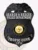Black shield-shaped metal badge topped with a detailed eagle, gold-bordered State of Hawaii seal in the center, white lettering for Tropic Cove police Search & Rescue unit, including badge number 172, secured by a safety pin attachment.