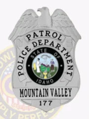 Mountain Valley police patrol badge in polished silver metal, eagle perched on top of a shield with "PATROL" arched over "POLICE DEPARTMENT," featuring the Idaho state emblem at the center, and "MOUNTAIN VALLEY 177" displayed prominently at the bottom, finished with a safety pin fastener.