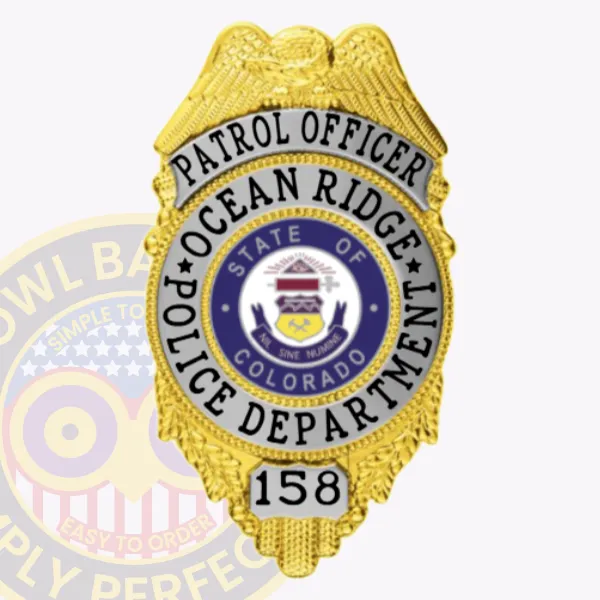 Shield-shaped gold metal badge for Ocean Ridge police patrol officer with silver accent panels, featuring a raised gold eagle at the top, black lettering "PATROL OFFICER" on silver background and "OCEAN RIDGE POLICE DEPARTMENT" surrounding the Colorado state seal, plus badge number "158" on a silver panel, secured by a safety pin.