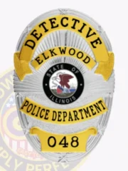 A visually appealing custom metal badge in silver with gold panels and a safety pin attachment, prominently featuring "DETECTIVE" at the top. The central area showcases the state seal of Illinois, framed by gold detailing that adds elegance. The polished silver surface reflects light beautifully, making it stand out.