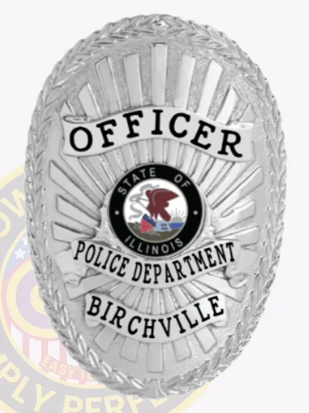 An elegant custom metal badge in silver with safety pin attachment showcases "OFFICER" prominently at the top in striking black text. Beneath, "POLICE DEPARTMENT" stands out clearly, with "BIRCHVILLE" displayed below. The central design features the state seal of Illinois, adding to the badge's official appearance.
