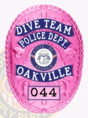 This stylish custom metal badge in BCAM pink with reverse enamel blue accents and with safety pin attachment highlights "DIVE TEAM" prominently at the top in bright white letters. Below, "POLICE DEPT." is clearly visible, complemented by decorative blue accents. The state seal of Georgia is centered within the badge, while "OAKVILLE" is showcased in bold blue beneath, finishing with the number "044" at the bottom.