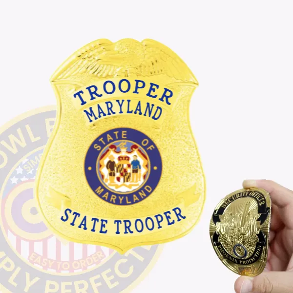 A custom flex badge in gold with blue lettering, featuring the word "TROOPER" at the top and "MARYLAND" just below it. The badge displays the emblem for the "STATE OF MARYLAND" in the center, with "STATE TROOPER" written at the bottom. A hand is holding a smaller version of a similar badge, highlighting its flexible design and polished gold finish against the blue lettering.