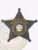 Metal bail enforcement agent badge in black shaped as a five-point star, detailed with embossed patterns, a center circle displaying the District of Columbia seal, and gold lettering "Washington DC Bail Enforcement Agent," secured by a safety pin.