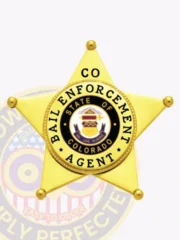 Custom metal badge in gold shaped like a 5 point star for bail enforcement agents, featuring a central circular emblem with the Colorado state seal, black text reading "Bail Enforcement Agent," and "CO" on the top star tip, fastened with safety pin attachment.