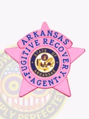 BCAM-themed pink metal badge shaped as a 5-point star for fugitive recovery agents in Arkansas, displaying "ARKANSAS FUGITIVE RECOVERY AGENT" in blue around the central gold and navy state seal, secured with a safety pin fastener.