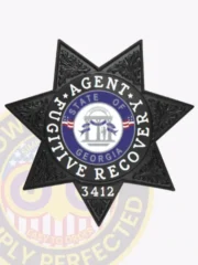 Black seven-point star badge with intricate embossed designs, showing a white and blue circle in the center with the text "Fugitive Recovery Agent" and the Georgia state seal, including a unique ID number "3412," designed as a custom metal badge with safety pin backing for fugitive recovery agents in Georgia.