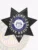 Black seven-point star badge with intricate embossed designs, showing a white and blue circle in the center with the text "Fugitive Recovery Agent" and the Georgia state seal, including a unique ID number "3412," designed as a custom metal badge with safety pin backing for fugitive recovery agents in Georgia.