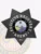 Black 7-point star metal badge designed for Florida fugitive recovery agents, displaying "FUGITIVE RECOVERY AGENT" in white around the central Florida state emblem, detailed with ornate black engraving and finished with a safety pin fastener.