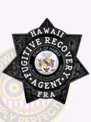 Custom black metal 7 point star badge highlighted by intricate black embossing, containing a central round seal labeled "Hawaii Fugitive Recovery Agent" around the official State of Hawaii symbol, with "FRA" on a banner below, finished with a safety pin fastener for fugitive recovery agents in Hawai'i.