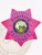 Pink BCAM 7 point star metal badge with detailed raised designs on every point, showing a central blue and gold Idaho state seal encircled by the words "Fugitive Recovery Agent" in blue letters, along with the numeric ID "456789123" above, finished with a safety pin fastener for fugitive recovery agents in Idaho.