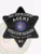 Black six-point star metal badge featuring “BAIL ENFORCEMENT AGENT” in bold white letters at the top, “OPERATIONS MANAGER” below the center seal, and “UNITED STATES” on the bottom banner, with the Wisconsin state emblem in the middle, attached with a safety pin.