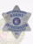 Metal badge shaped as a silver 6 point star with blue embossed text reading “BAIL ENFORCEMENT AGENT INVESTIGATOR UNITED STATES” surrounding the official Wisconsin state seal in the center, made for bail enforcement agents with a safety pin fastener.