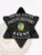 California fugitive recovery agent badge in black metal shaped as a 6-point star, with white lettering "UNITED STATES FUGITIVE RECOVERY AGENT" surrounding the detailed state seal and a series of numbers below, finished with a safety pin attachment.