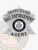 Silver metal badge shaped as a six-point star with embossed black lettering “UNITED STATES BAIL ENFORCEMENT AGENT” on curved banners above and below the star, centered by the Wyoming state emblem, made specifically for bail enforcement agents with a safety pin.